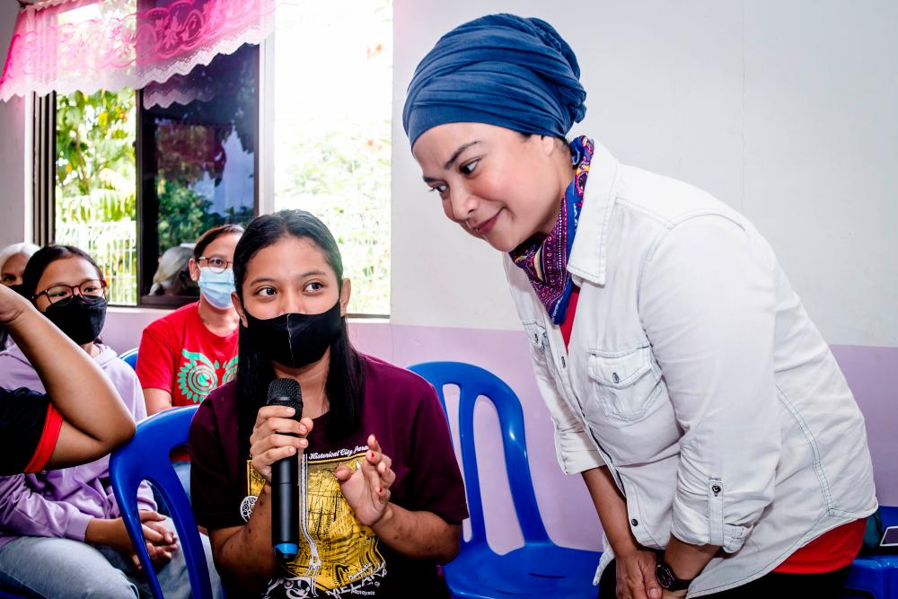 $!Kartini Ariffin engaging with a workshop participant from the Orang Asli village.
