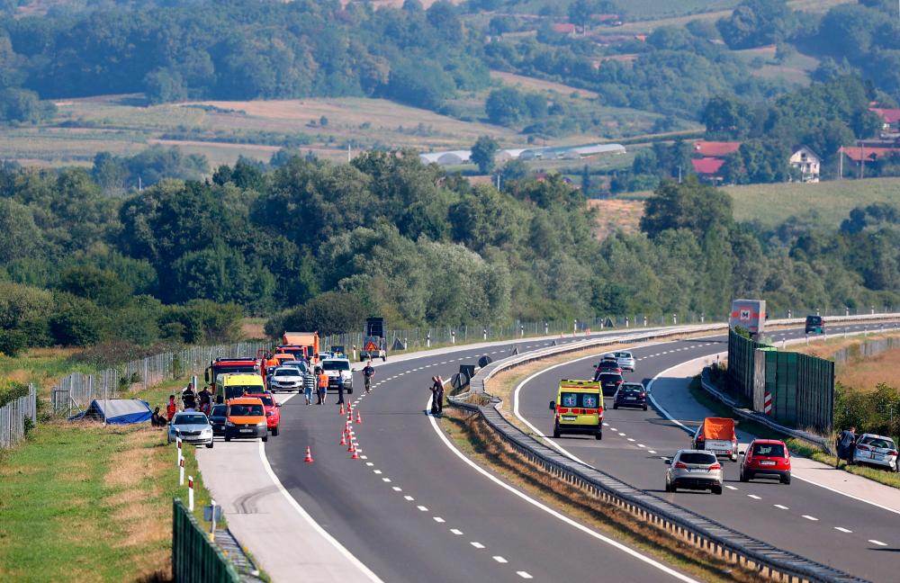 Police and emergency services are parked on the Varazdin-Zagreb highway next to the wreckage of the bus after the accident that happened early this morning some 50 kilometers from Zagreb, on August 6, 2022. AFPPIX