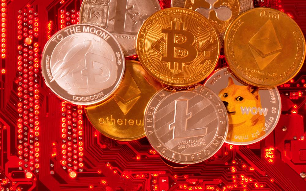 File photo: Representations of cryptocurrencies Bitcoin, Ethereum, DogeCoin, Ripple, Litecoin are placed on PC motherboard in this illustration taken, June 29, 2021. REUTERSpix