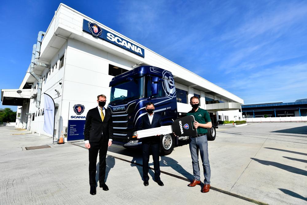 Scania Southeast Asia services director Thor Brenden (at right) handing over the lorry’s “key” to Xin Hwa Holdings Bhd managing director Ng Aik Chuan (middle), witnessed by guest-of-honour, Swedish ambassador H.E. Dr Joachim Bergstrom.