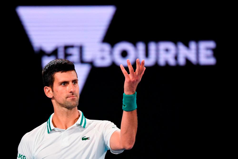 (FILES) In this file photo taken on February 21, 2021, Serbia’s Novak Djokovic reacts after a point against Russia’s Daniil Medvedev during their men’s singles final match on day fourteen of the Australian Open tennis tournament in Melbourne. AFPpix