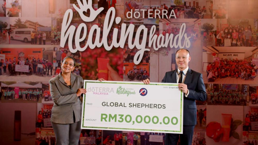 General Manager of doTERRA Malaysia, Ethan Wang (right) handing over a mock cheque to Brittocia Franklin of Global Shepherds
