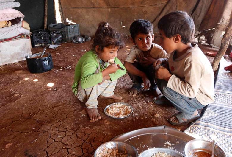 Internally displaced children, who along with their family fled the violence in Aleppo’s Handarat area, eat inside a tent in the northern countryside of Aleppo, October 8, 2014. REUTERSPIX