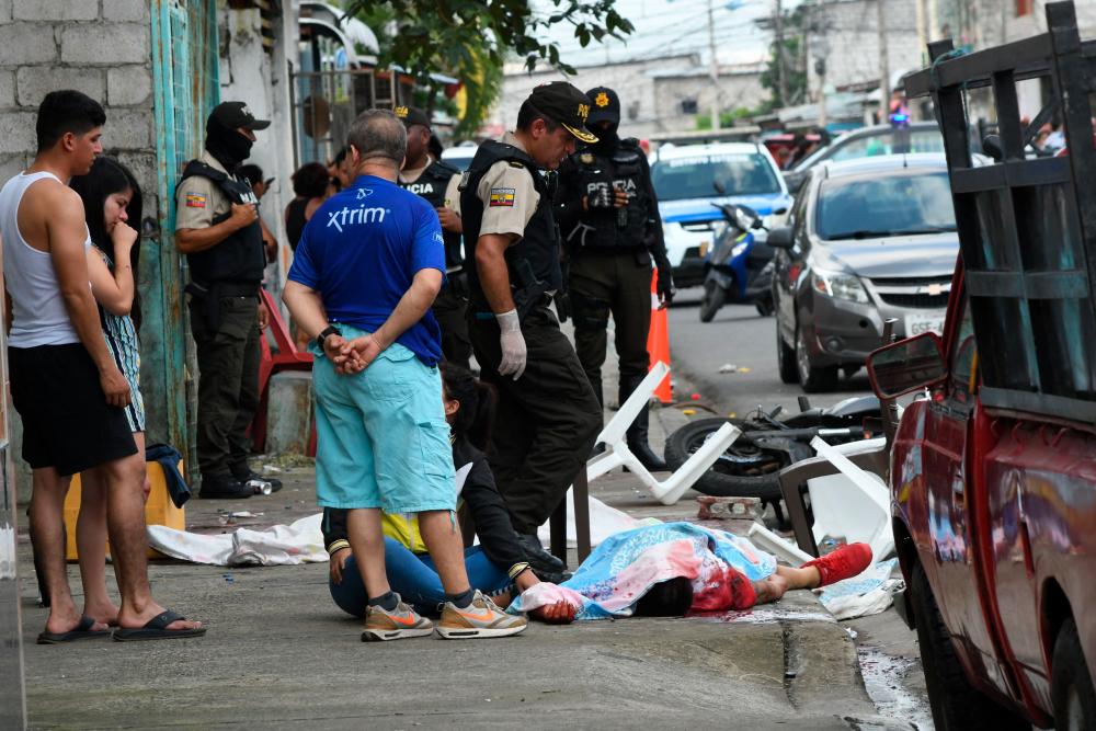 A police expert examines the body of a person killed during a shooting in Guayaquil, Ecuador, on June 4, 2023/AFPPix
