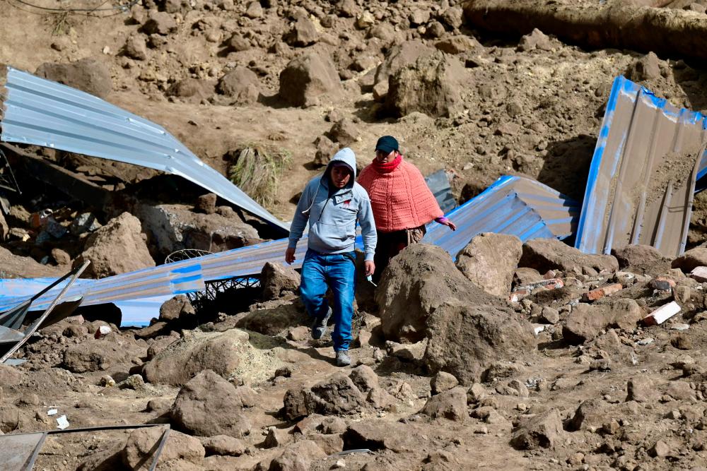 Residents abandon their homes after a landslide in Alausi, Ecuador on March 28, 2023/AFPPix