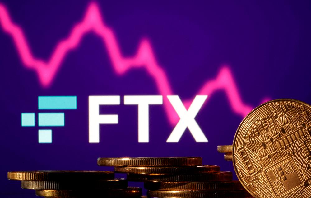 Representations of cryptocurrencies are seen in front of displayed FTX logo and stock graph in this illustration. – Reuterspic