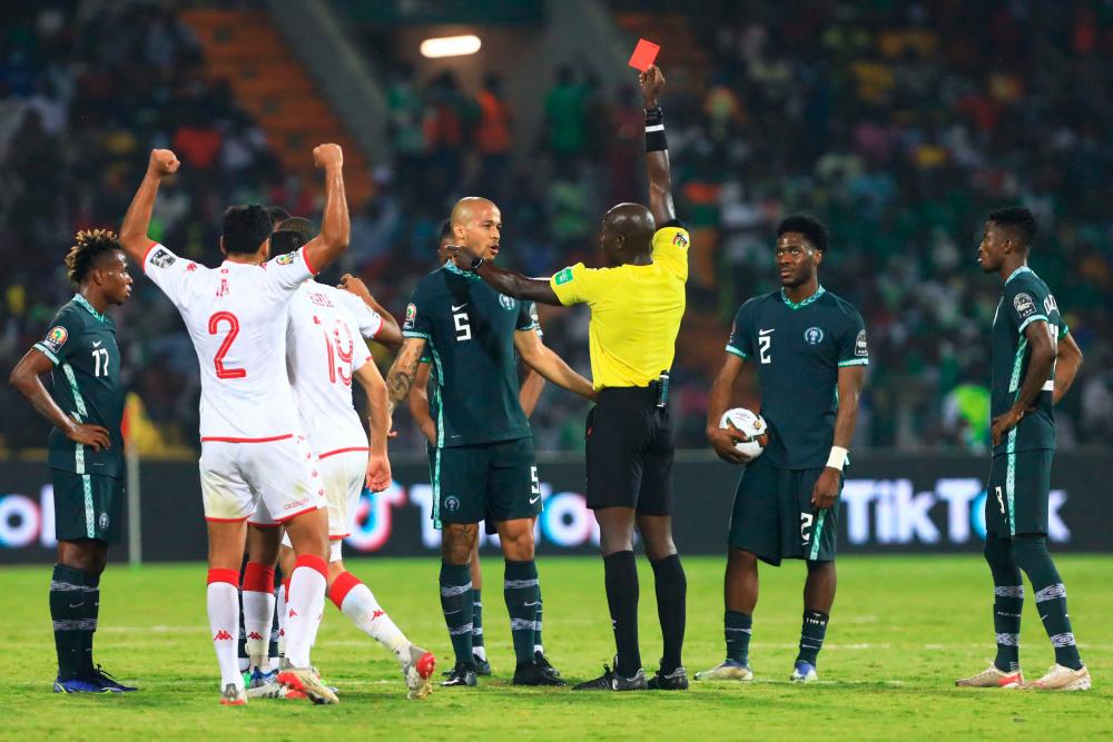 Senegalese referee Maguette N’Diaye (C) gives a red card to Nigeria’s forward Alex Iwobi (unseen) during the Africa Cup of Nations (CAN) 2021 round of 16 football match between Nigeria and Tunisia at Stade Roumde Adjia in Garoua on January 23, 2022. AFPPIX