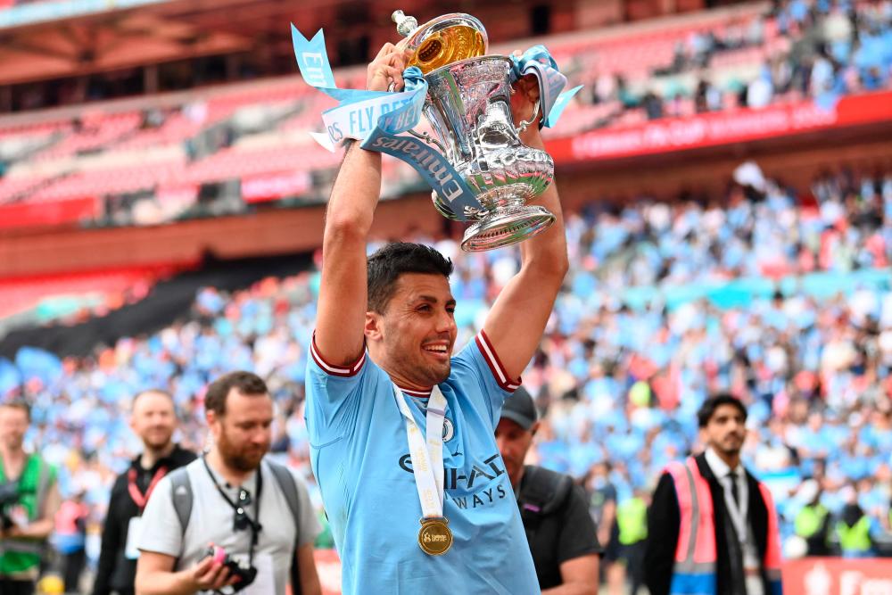 Manchester City’s Spanish midfielder Rodri celebrates with the trophy on the pitch after the English FA Cup final football match between Manchester City and Manchester United at Wembley stadium, in London, on June 3, 2023/AFPPix