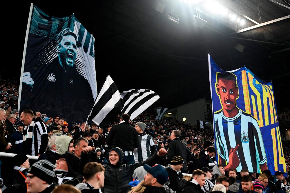 Newcastle’s supporters hold a banner depicting Newcastle United’s English head coach Eddie Howe (L) and Newcastle United’s Swedish striker Alexander Isak (R) prior to the English League Cup semi final football match between Newcastle United and Southampton at St James’s Park stadium in Newcastle, on January 31, 2023. AFPPIX