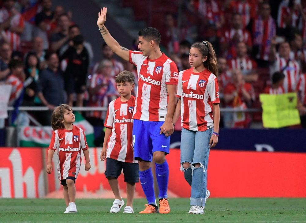 Luis Suarez acknowledges the crowd as he walks around the pitch with his children during his farewell as Atletico player at the end of the Spanish league football match between Atletico Madrid and Sevilla at the Wanda Metropolitano stadium in Madrid. AFPPIX