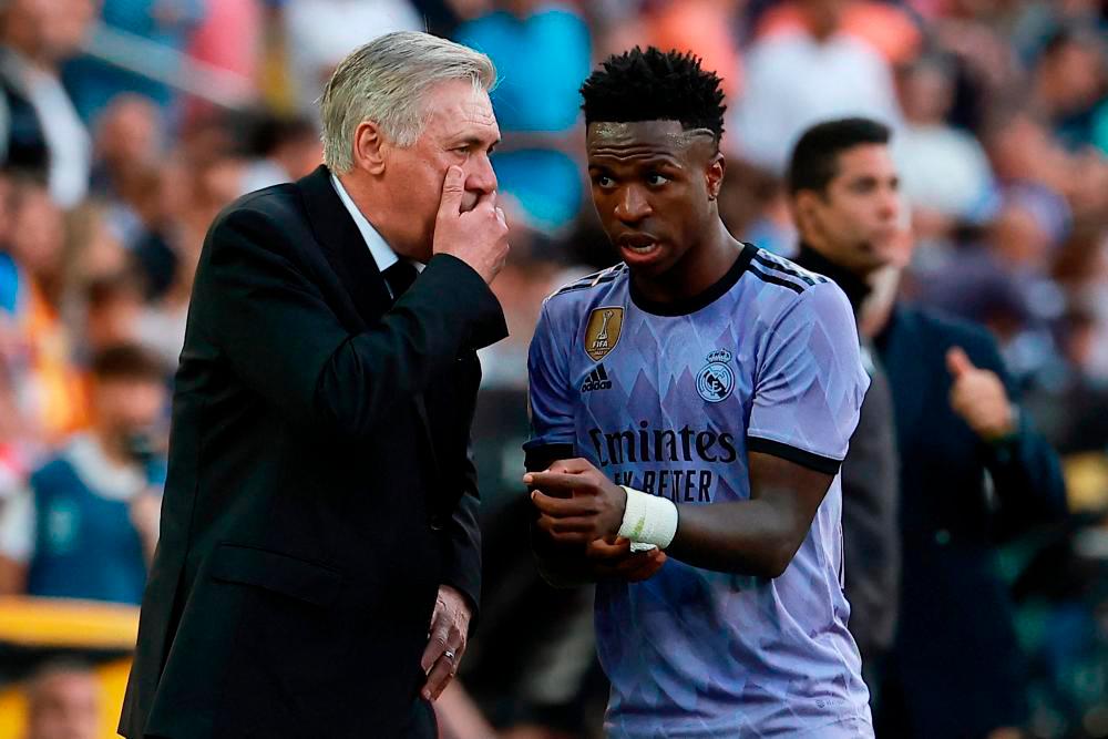 Vinicius Junior listens to Carlo Ancelotti (L) during the Spanish league football match between Valencia CF and Real Madrid CF at the Mestalla stadium in Valencia on May 21, 2023. AFPPIX