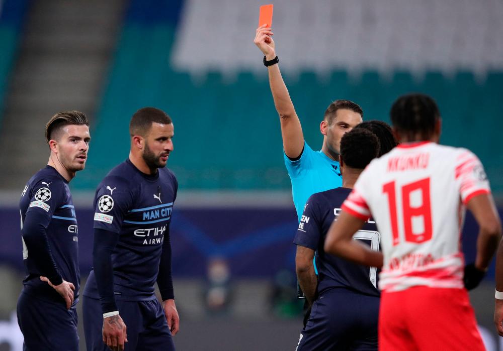 Manchester City's English defender Kyle Walker (2nd L) is shown a red card by the Swiss referee Sandro Schaerer during the UEFA Champions League, Group A, football match RB Leipzig v Manchester City in Leipzig, eastern Germany on December 7, 2021. AFPpix