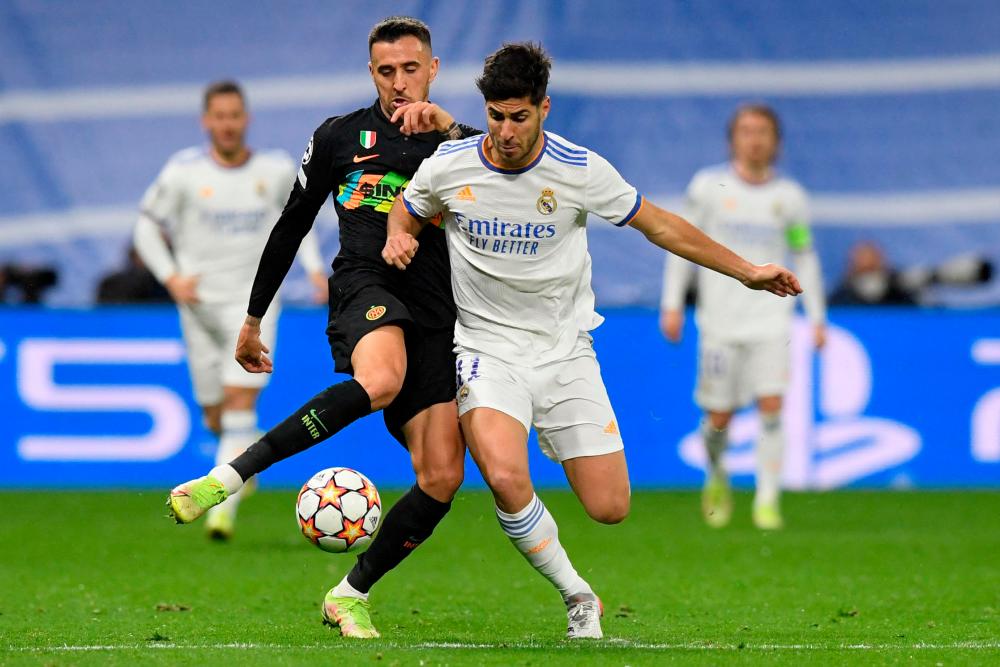Inter Milan's Uruguayan midfielder Matias Vecino (L) vies with Real Madrid's Spanish midfielder Marco Asensio during the UEFA Champions League first round group D football match between Real Madrid and Inter Milan at the Santiago Bernabeu stadium in Madrid on December 7, 2021. AFPpix