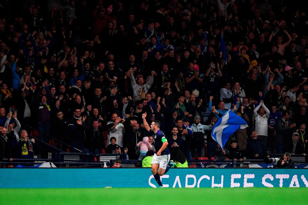Scotland's supporters celebrate after Scotland's midfielder John McGinn (C) scored the first goal during the UEFA Nations League B Group 1 football match at Hampden Park stadium, in Glasgow, on September 21, 2022. AFPPIX