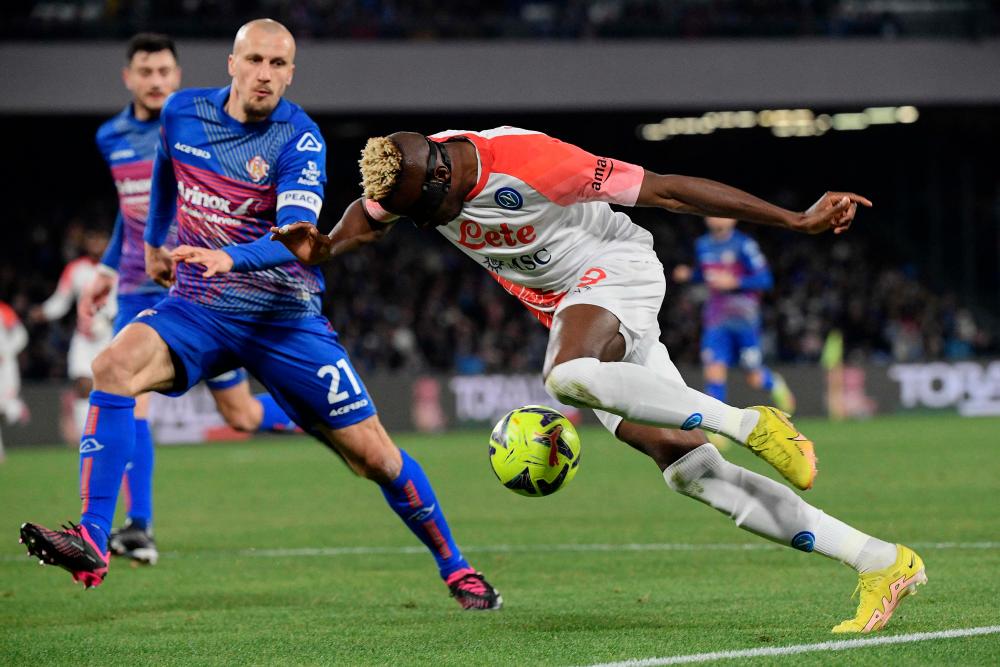 Napoli’s Nigerian forward Victor Osimhen (R) challenges Cremonese’s Romanian defender Vlad Chiriches during the Italian Serie A football match between Napoli and Cremonese on February 12, 2023 at the Diego-Maradona stadium in Naples. AFPPIX