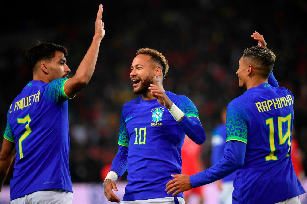 Brazil's forward Neymar (C) celebrates with Brazil's midfielder Lucas Paqueta (L) and Brazil's forward Raphinha (R) after scoring his team's third goal during the friendly football match between Brazil and Tunisia at the Parc des Princes in Paris on September 27, 2022. AFPPIX