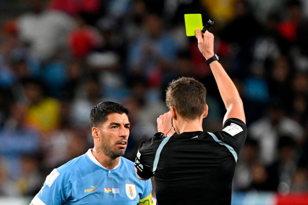 German referee Daniel Siebert (R) shows a yellow card to Uruguay’s forward #09 Luis Suarez (L) during the Qatar 2022 World Cup Group H football match between Ghana and Uruguay at the Al-Janoub Stadium in Al-Wakrah, south of Doha on December 2, 2022/AFPPix