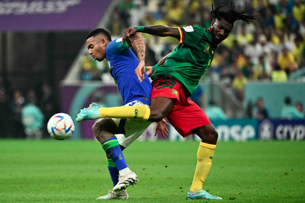 Brazil's forward #18 Gabriel Jesus (L) fights for the ball with Cameroon's midfielder #08 Andre-Frank Zambo Anguissa (R) during the Qatar 2022 World Cup Group G football match between Cameroon and Brazil at the Lusail Stadium in Lusail December 2, 2022. - AFPPIX