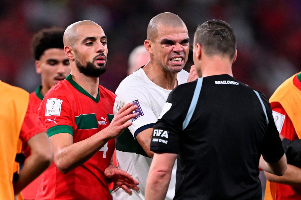 Portugal's defender #03 Pepe (C) argues with Argentinian referee Facundo Tello next to Morocco's midfielder #04 Sofyan Amrabat (L) during the Qatar 2022 World Cup quarter-final football match between Morocco and Portugal at the Al-Thumama Stadium in Doha on December 10, 2022. AFPPIX