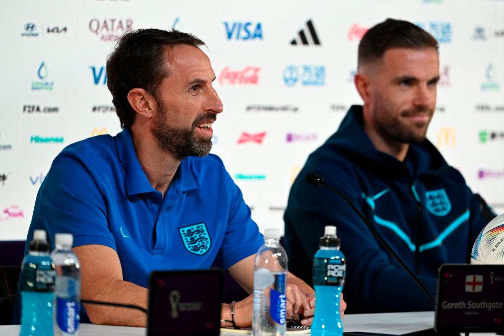 England’s coach Gareth Southgate (L) and England’s midfielder Jordan Henderson give a press conference at the Qatar National Convention Center (QNCC) in Doha on November 28, 2022, on the eve of the Qatar 2022 World Cup football match between Wales and England. AFPPIX
