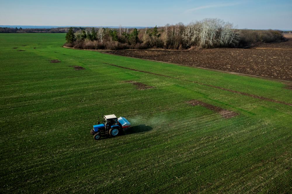 A tractor is seen spreading fertiliser on a wheat field near a village outside Kharkiv, Ukraine. The World Bank president says developing countries are being hit even harder given shortfalls of fertiliser and food stocks and energy supplies. – Reuterspix