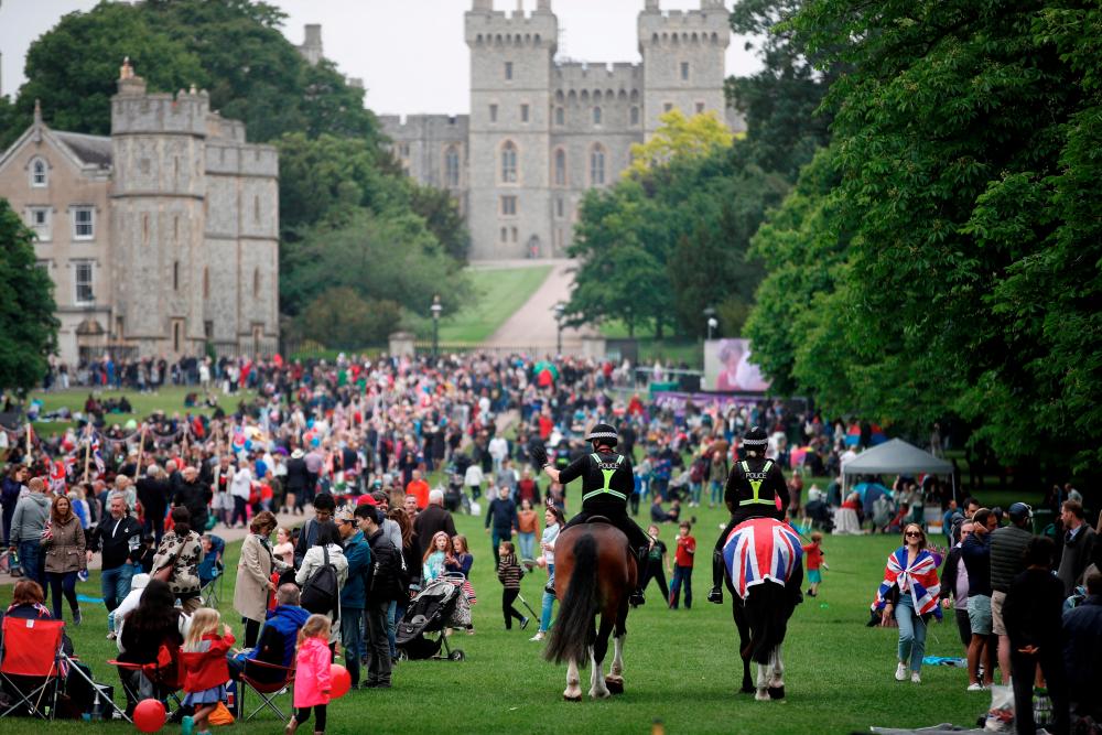 FILE PHOTO: Police officers ride on horses past the crowd as people take part in the Big Jubilee Lunch on The Long Walk as part of celebrations marking the Platinum Jubilee of Britain's Queen Elizabeth, in Windsor, Britain, June 5, 2022. REUTERSPIX