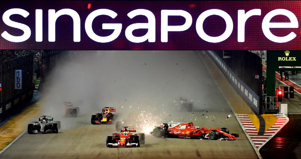 (FILES) In this file photo taken on September 17, 2017, the car of Ferrari’s Finnish driver Kimi Raikkonen (R) is seen after a crash beside Ferrari’s German driver Sebastian Vettel (C) during the Formula One Singapore Grand Prix in Singapore. AFPPIX