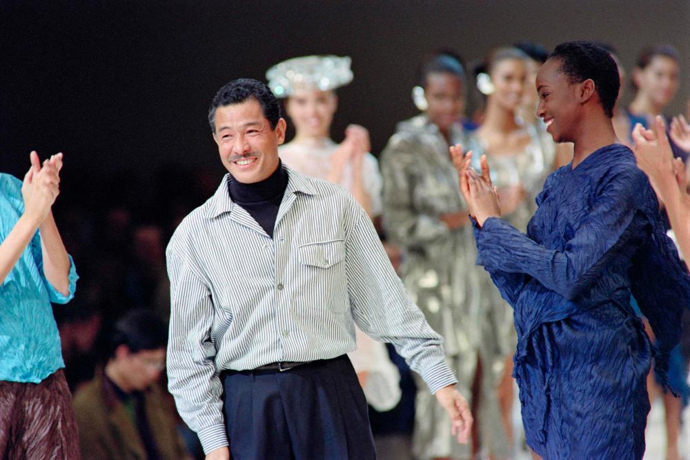 (FILES) This file photo taken on October 19, 1991 shows Japanese fashion designer Issey Miyake acknowledging the applause from models and attendees after presenting his 1992 Spring-Summer collection in Paris. AFPPIX