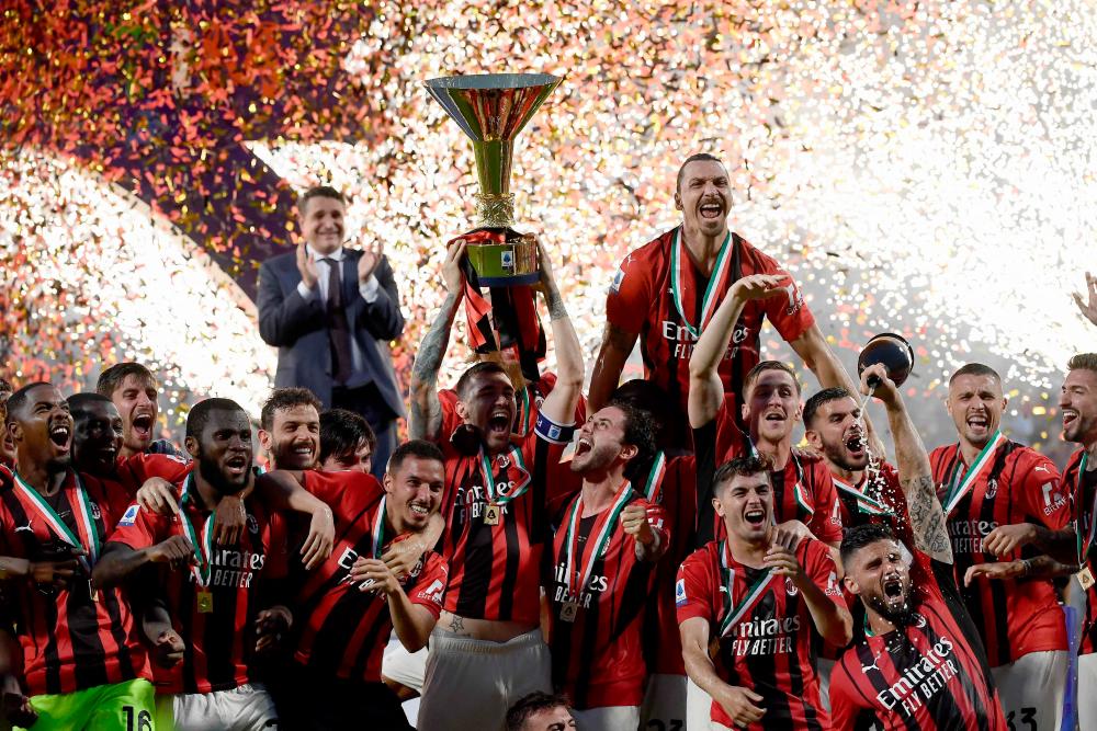 (FILES) This file photo taken on May 22, 2022 shows AC Milan’s Italian defender Alessio Romagnoli (C-L with throphy), AC Milan’s Swedish forward Zlatan Ibrahimovic (Top R), AC Milan’s French forward Olivier Giroud (Bottom R) and AC Milan’s players celebrating with the winner’s trophy after AC Milan won the Italian Serie A football match between Sassuolo and AC Milan, securing the “Scudetto” championship at the Mapei - Citta del Tricolore stadium in Sassuolo. AFPPIX