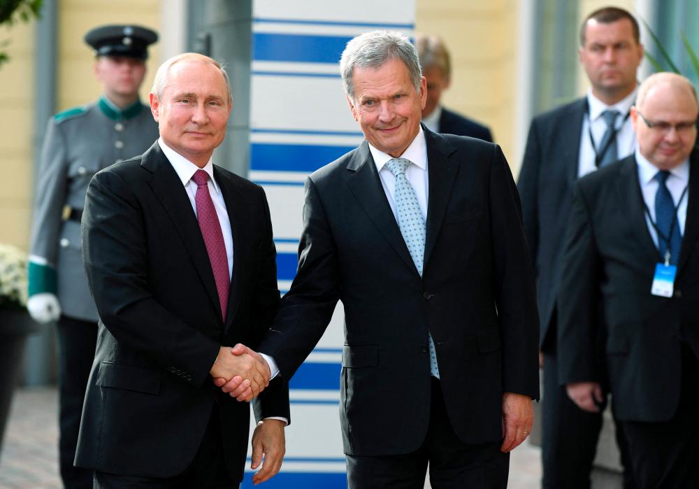 This file photo taken on August 21, 2019 shows Russian President Vladimir Putin (L) shaking hands with Finnish President Sauli Niinisto (C) at the Presidential Palace in Helsinki/AFPPix