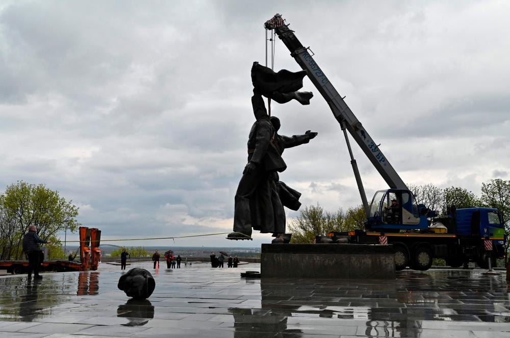 In this file photo taken on April 26, 2022 workers dismantle the Soviet monument to Ukraine-Russia friendship in Kyiv on April 26, 2022, amid Russian invasion of Ukraine/AFPPix