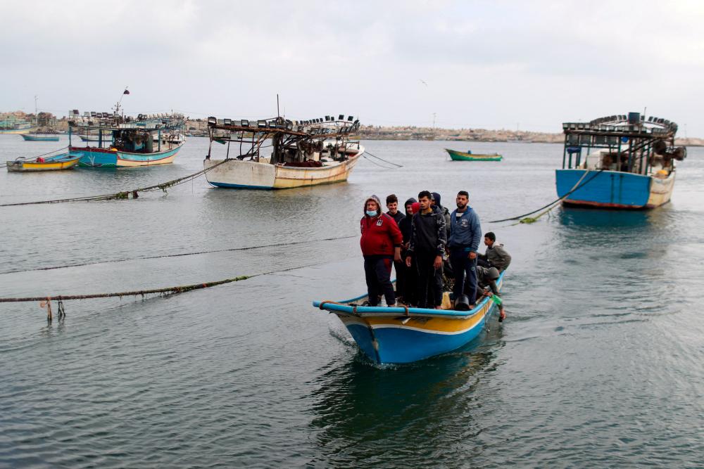 File photo: Palestinian fishermen riding on a boat make their way back after Israel restricted Palestinian fishing zone in response to Palestinian rockets, at the seaport of Gaza City April 26, 2021. REUTERSpix