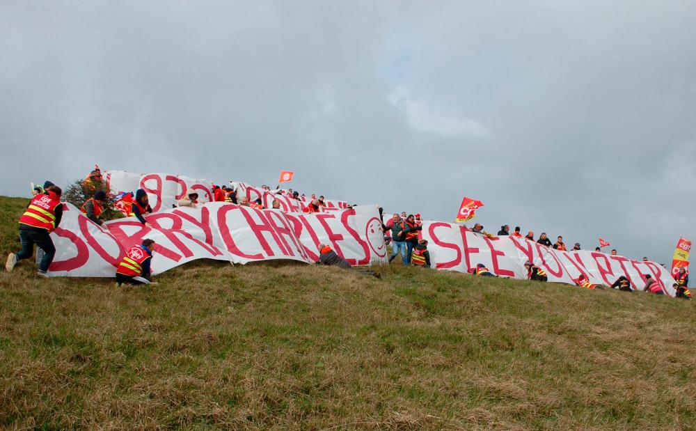 French union members unfurl banners including one reading “Sorry Charles, see you later” after a trip by Britain’s King Charles III to France was postponed in the wake of violent protests over a pensions reform, at the summit of the Cap Blanc-Nez, near Escalles, northern France, on March 30, 2023/AFPpix