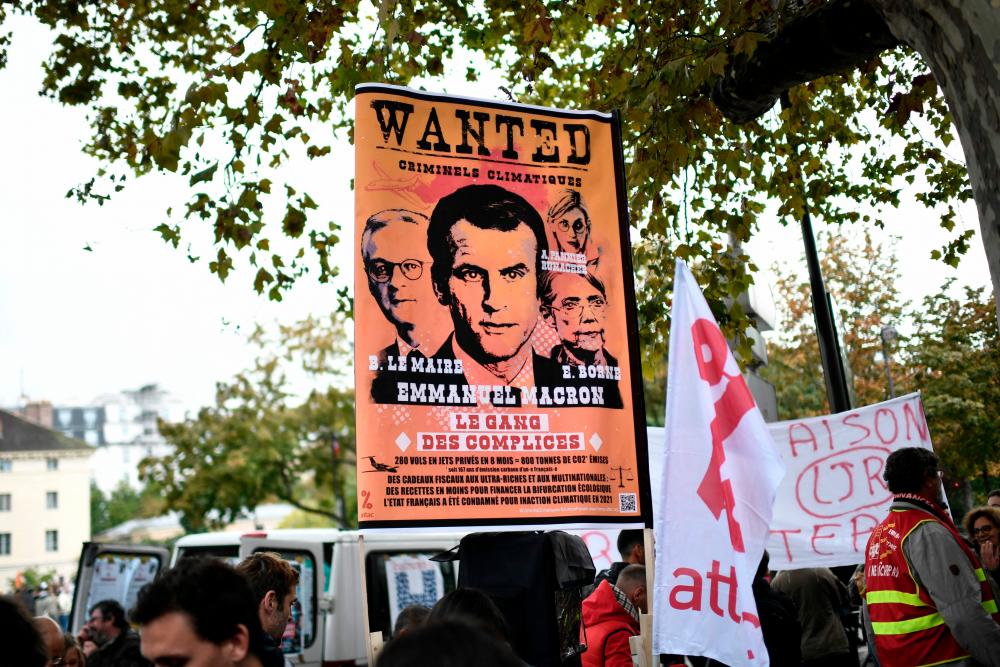 A banner bearing a portrait of France’s President Emmanuel Macron reading ‘Wanted’ is seen during a rally as part of a nationwide day of workers strike to push for wage hikes and the end of planned pension reform in Paris on September 29, 2022. AFPPIX