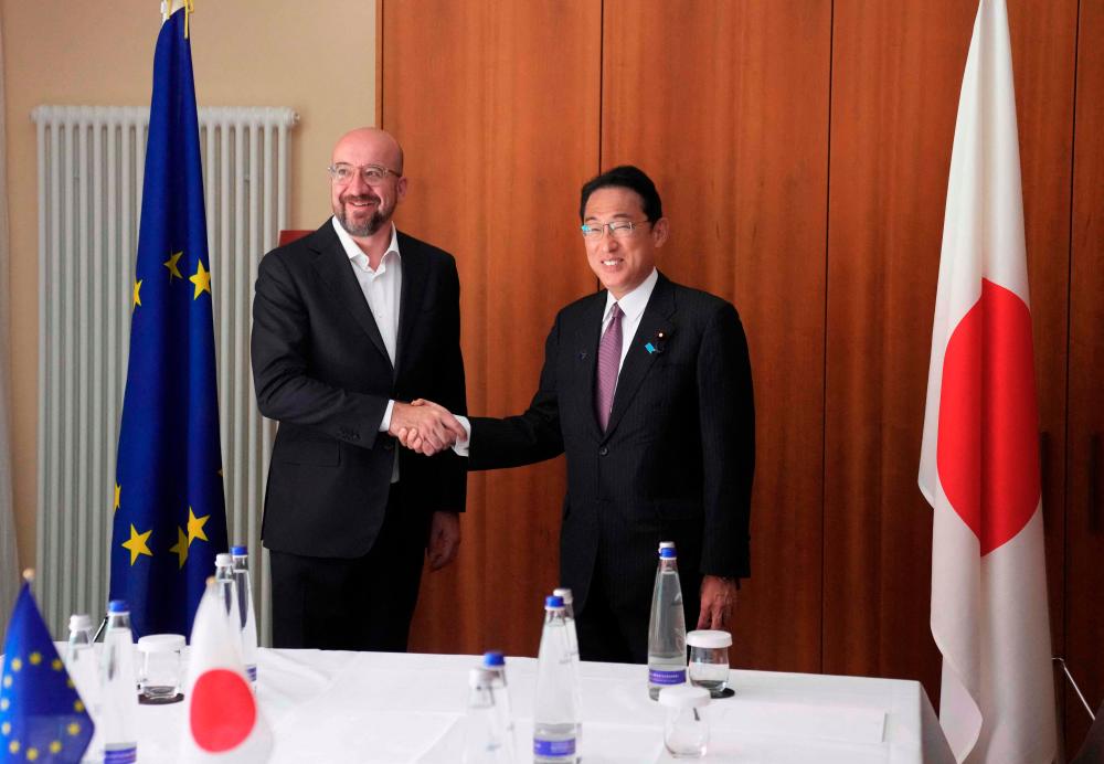 European Council President Charles Michel (left) shakes hands with Japan's Prime Minister Fumio Kishida prior to a meeting on the sidelines of the G7 summit at Elmau Castle, southern Germany. – AFPPIX