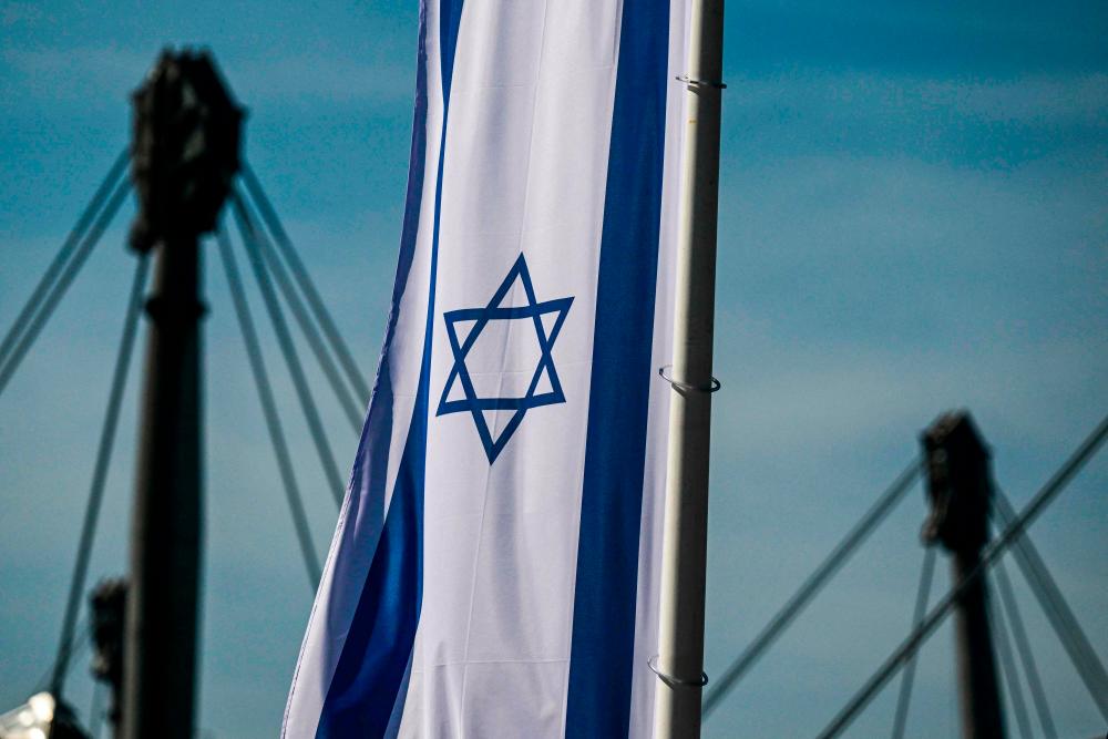 An Israeli flag is seen on August 17, 2022 at the Olympic park in Munich, southern Germany, as 50 years ago, on September 5 and 6, 1972 were killed in a terrorist attack by Palestinian militants 11 Israeli athletes and coaches and a German police officer during the 1972 Munich Olympic Games. Israel and Germany on August 17, 2022 condemned remarks by Palestinian president Mahmud Abbas in Berlin, where he compared the Holocaust to the Jewish state's killings of Palestinians. AFPPIX