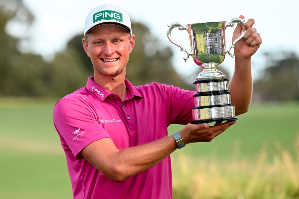 Poland's Adrian Meronk holds the trophy after winning the men's Australian Open golf tournament at the Victoria course in Melbourne on December 4, 2022. - AFPPIX