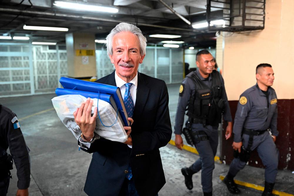 Guatemalan journalist Jose Ruben Zamora (L), president of the newspaper El Periodico, leaves after the hearing at the Justice Palace in Guatemala City on May 30, 2023/AFPPix