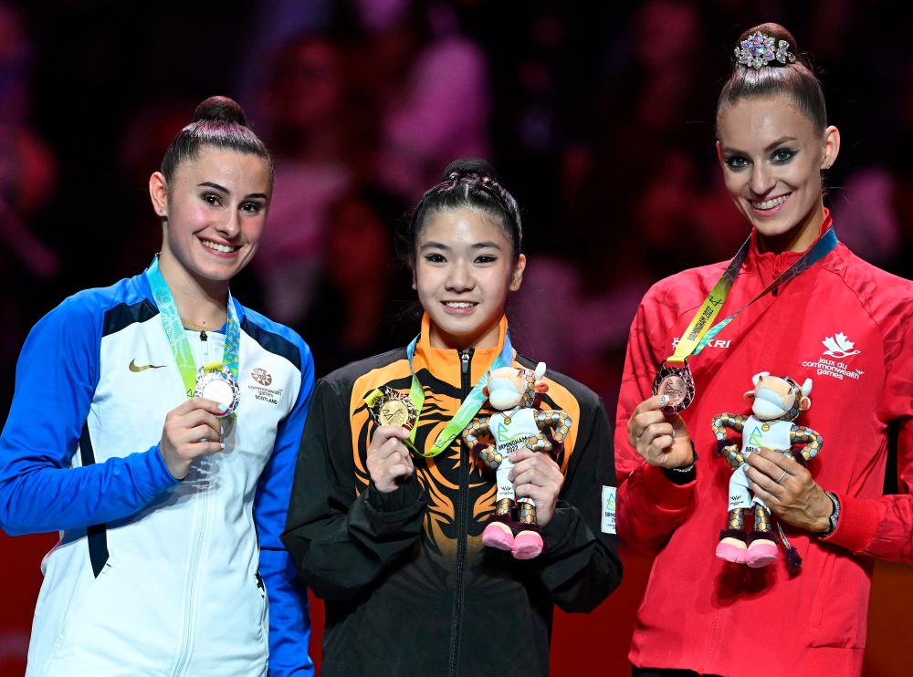 Silver medallist Scotland's Louise Christie (L), gold medallist Malaysia's Joe Ee Eng (C) and Bronze medallist Canada's Carmel Kallemaa pose during the medal ceremony for the ribbon rhythmic gymnastics event at the Arena Birmingham, on day nine of the Commonwealth Games in Birmingham, central England, on August 6, 2022. AFPPIX
