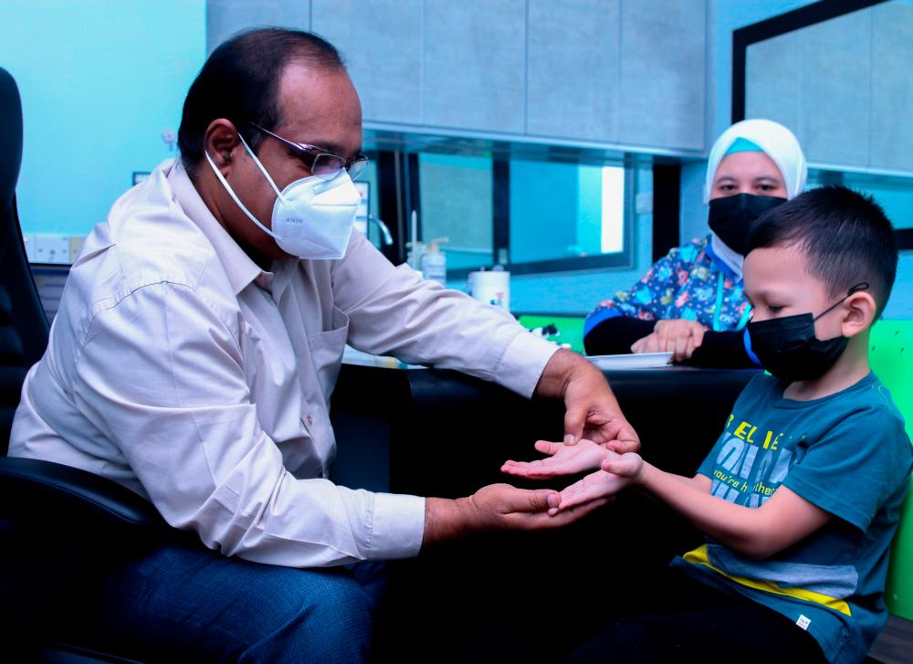 BUKIT MERTAJAM, 18 MAY-Penang KPJ Specialist Hospital Pediatrician, Dr Abdul Nasir Mohamed examined a child infected with Hand, Foot and Mouth Disease (HFMD). MASRY CHE ANI/THESUN