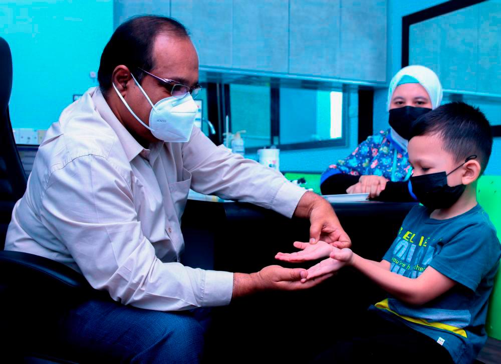 BUKIT MERTAJAM, 18 MEI - Pakar Kanak-kanak Hospital KPJ Specialist Pulau Pinang, Dr Abdul Nasir Mohamed memeriksa seorang kanak-kanak yang dijangkiti penyakit Tangan Kaki Dan Mulut (HFMD). MASRY CHE ANI/THESUN