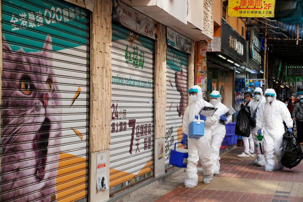 Officers in protective suits walk outside a closed pet shop in Mong Kok district after a hamster cull was ordered to curb the coronavirus disease (Covid-19) outbreak, in Hong Kong, China, January 19, 2022. REUTERSpix