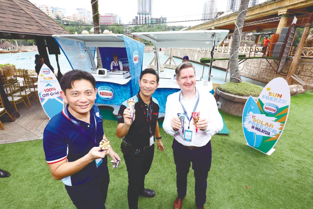 (Clockwise, from R) Teo, Ho and Mayer enjoying an ice-cream treat at the launch of Nestle’s solar-powered ice-cream kiosk. – NESTLE MALAYSIA