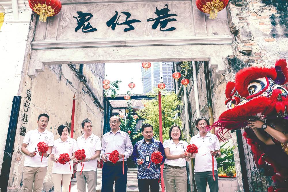 Bai Chuan Management executives, together with Chang (second from right) and local city officials, opening the gates to the bridge to Kwai Chai Hong; and its many painted murals. – ADIB RAWI YAHYA/ THESUN
