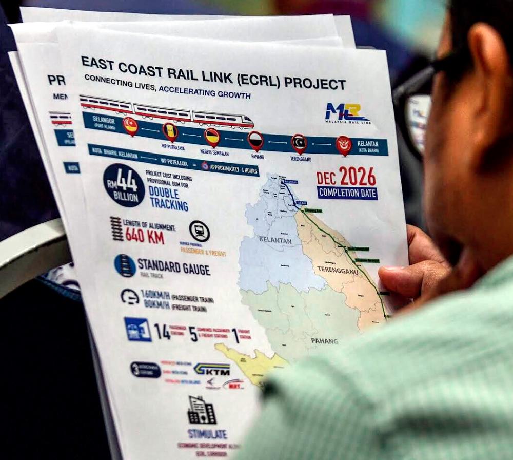 A man looks at a leaflet on the East Coast Rail Link (ECRL) project at Perdana Putra, Putrajaya on April 15, 2019. — Sunpix by Ashraf Shamsul