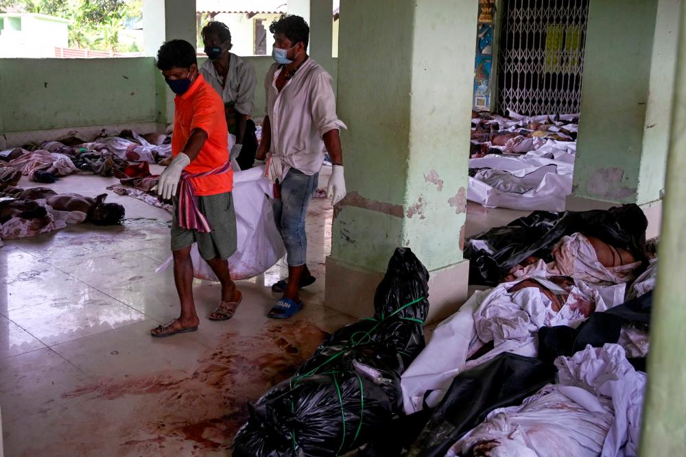 Rescue workers carry the body of a victim at a high school used as temporary mortuary to identify the dead recovered from a carriage wreckage of a three-train collision near Balasore, in India’s eastern state of Odisha, on June 3, 2023/AFPPix