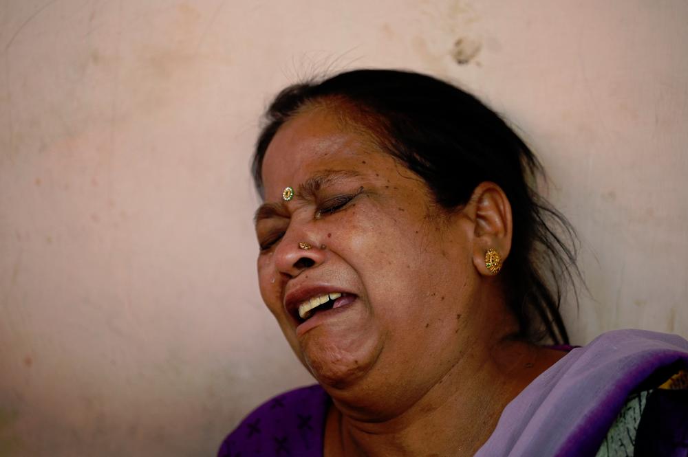 A relative griefs at a hospital as she waits for the body of her loved one a day after a fire broke out at a commercial building, in New Delhi. - AFPpix