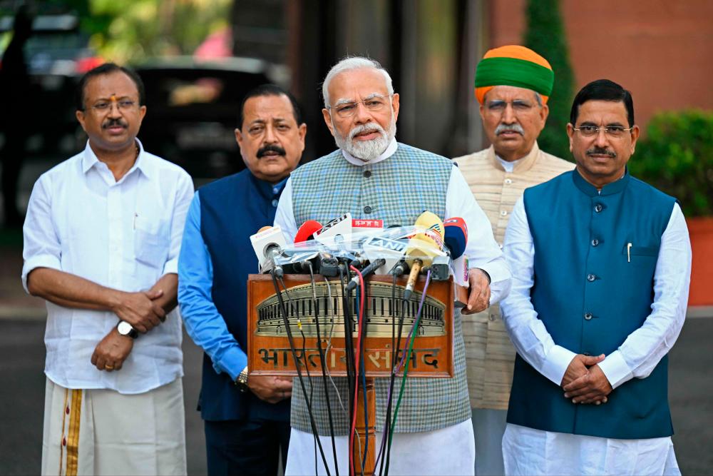 India's Prime Minister Narendra Modi (C) along with lawmakers, addresses the media representatives upon his arrival to attend the special session of the parliament in New Delhi on September 18, 2023. AFPPIX