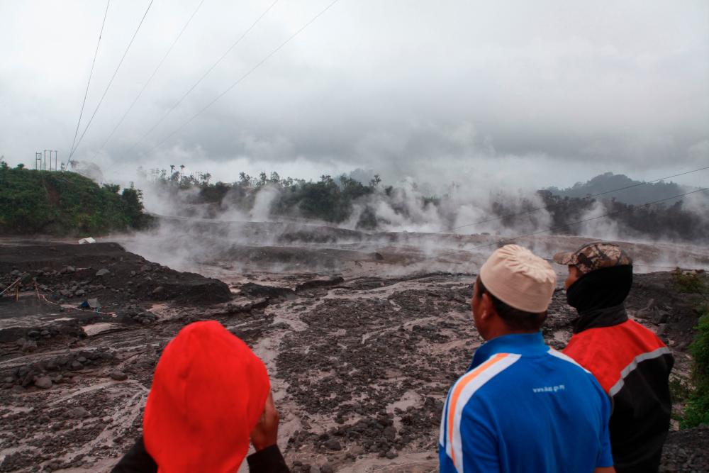 Villagers watch hot smoke from the ground following Mount Semeru's volcanic eruption in Lumajang, East Java on December 4, 2022. AFPPIX
