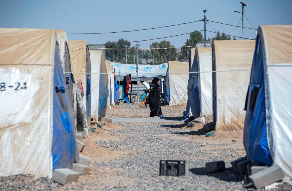 A woman walks near her tent at the Jadaa rehabilitation camp for the displaced near the northern Iraqi city of Mosul, on May 11, 2022. AFPPIX
